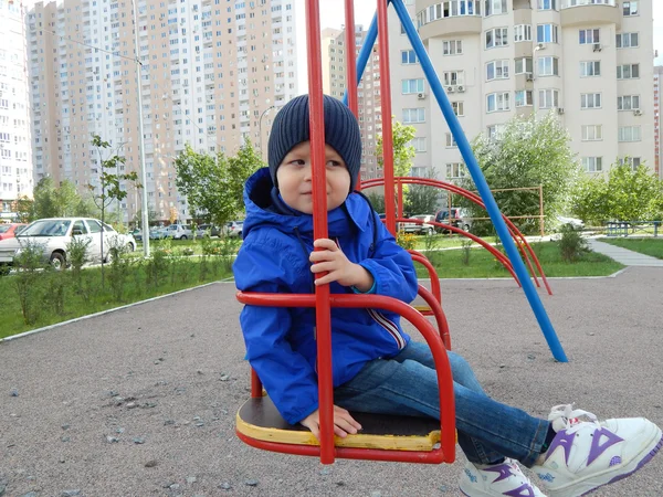 A child on a swing in the city — Stock Photo, Image