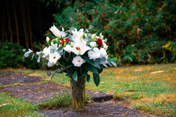 在花园里的小径上 一束白花插在花瓶里 — 图库照片