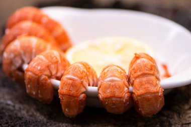 Koyu ahşap zemin üzerinde kaynatılmış büyük karides.