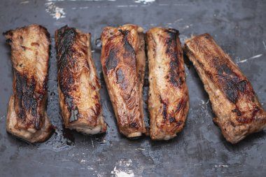 İştah açıcı kızarmış domuz pirzolası, kemiğin üzerinde koyu bir arka plan.