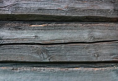 Eski ve gri ahşap arka planda eski tarz çatlaklar ve çizikler var.