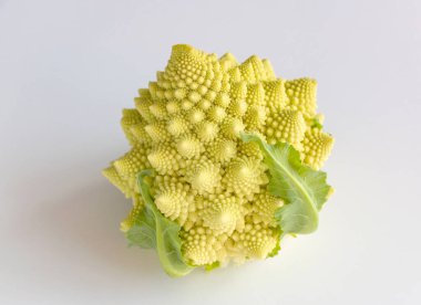 Beyaz ahşap arka planda yeşil yapraklı lezzetli Romanesco (brokoli)