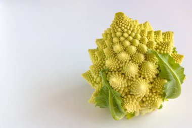 Beyaz ahşap arka planda yeşil yapraklı lezzetli Romanesco (brokoli)