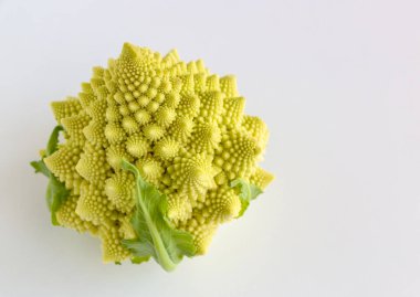 Beyaz ahşap arka planda yeşil yapraklı lezzetli Romanesco (brokoli)