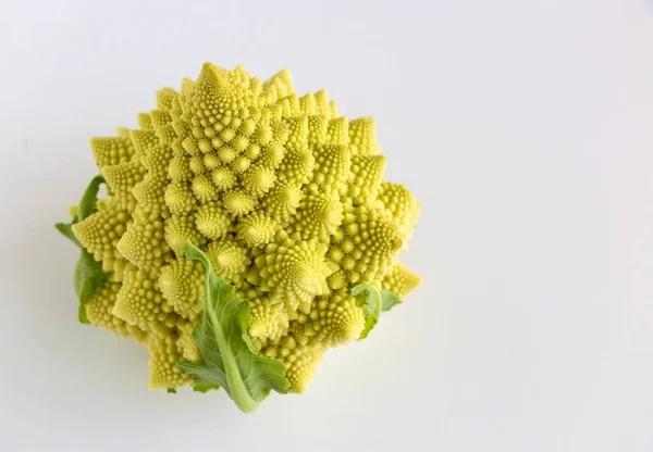 Beyaz ahşap arka planda yeşil yapraklı Lezzetli Romanesco (brokoli)