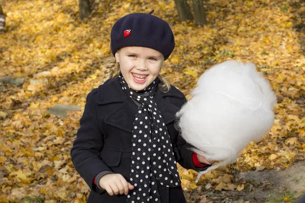 Cheerful little girl eating cotton candy — Stock Photo, Image