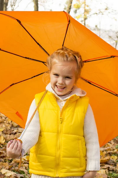 Schönes Mädchen versteckt sich unter einem Regenschirm — Stockfoto