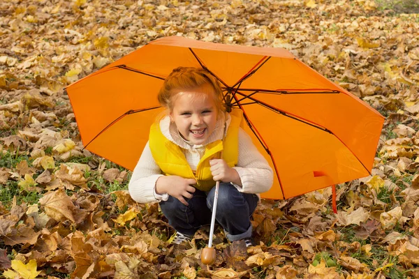 Menina bonita escondida sob um guarda-chuva — Fotografia de Stock