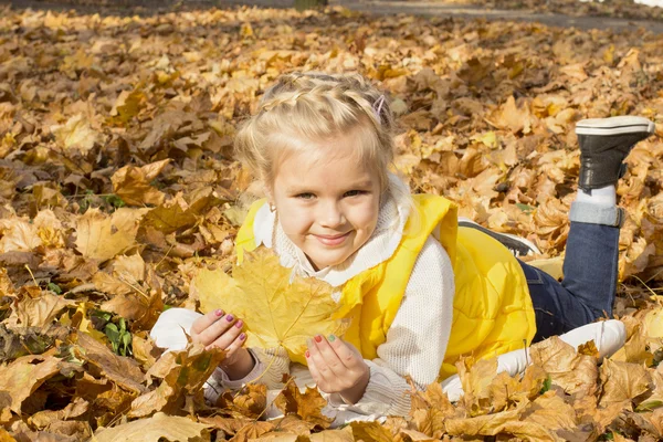 Belle fille gaie parmi les feuilles d'automne — Photo