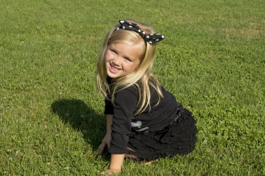 Yeşil çimenlerin üzerinde oturan kız