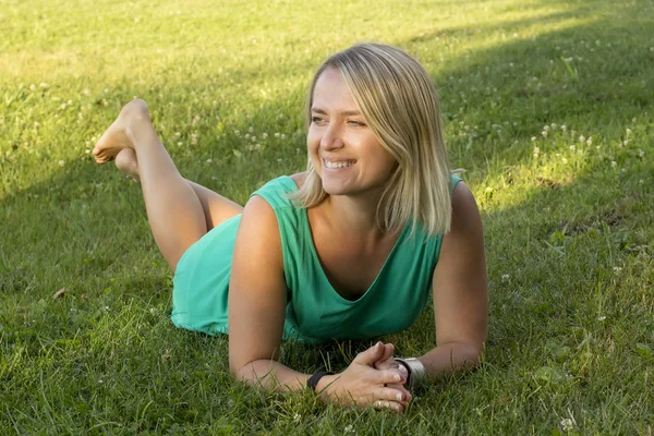 Girl smiling and lying on the grass — Stock Photo, Image