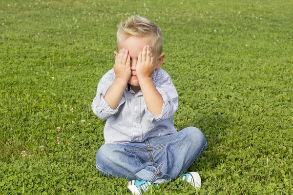 Niño sentado en la hierba —  Fotos de Stock