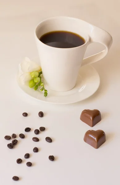 Chocolates next to a cup of coffee — Stock Photo, Image