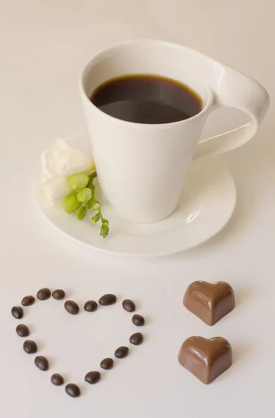 Chocolates next to a cup of coffee — Stock Photo, Image