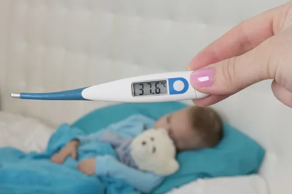 37,6 grader kroppstemperatur av ett barn Stockbild