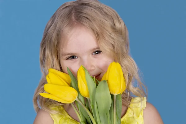 Menina sorrindo e segurando um buquê de flores — Fotografia de Stock