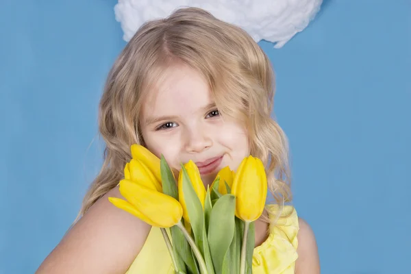 Meisje glimlachend en houden een boeket van bloemen — Stockfoto