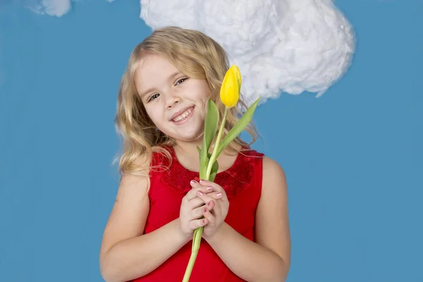 Niña sonriendo y sosteniendo un ramo de flores — Foto de Stock