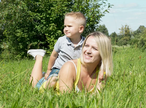Ligga på gräs mor och son — Stockfoto