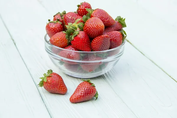 Red strawberry lying on a wooden surface — Stock Photo, Image