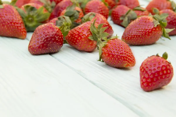 Aardbei verspreid over een houten oppervlak — Stockfoto