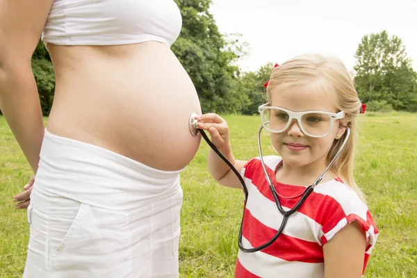 Menina ouvindo a barriga — Fotografia de Stock