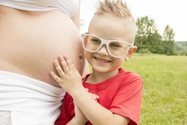 Junge hört schwangerem Bauch zu — Stockfoto