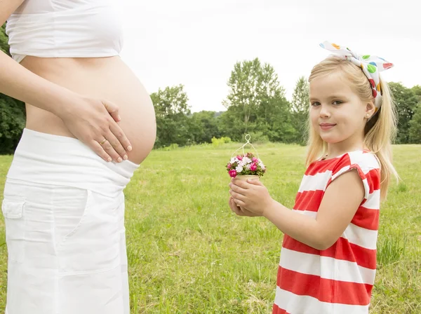 Flicka ger blommor till mamma — Stockfoto