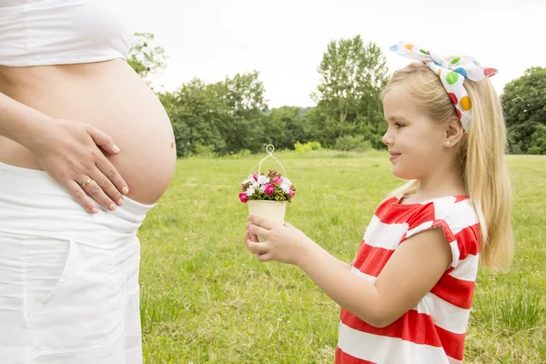 Mädchen schenkt Mama Blumen — Stockfoto