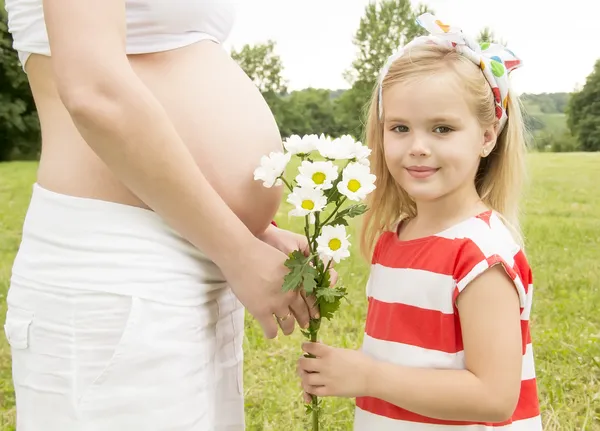 Flicka ger blommor till mamma Stockbild