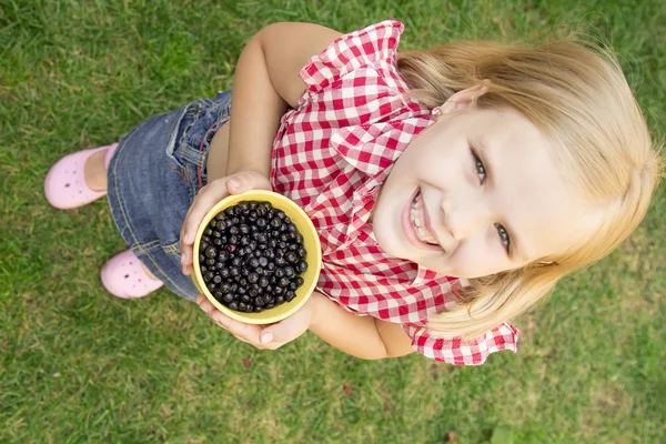 Girl holding blueberries in a bucket — Stock Photo, Image