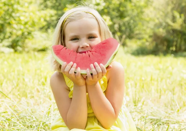 Girl eats watermelon in the meadow — Stock Photo, Image