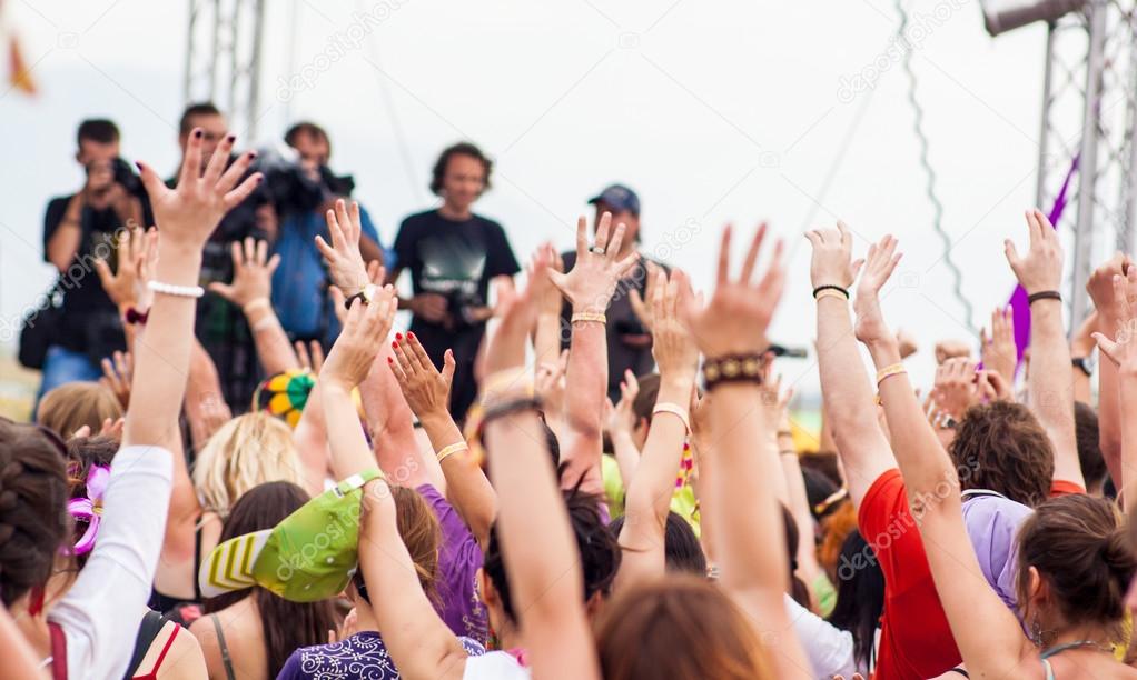 the crowd at the concert pulls his hands up