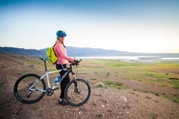 Meisje op een fiets in de bergen — Stockfoto