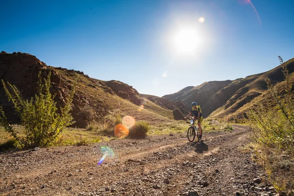 Ragazza in bicicletta ai raggi del sole nascente — Foto Stock