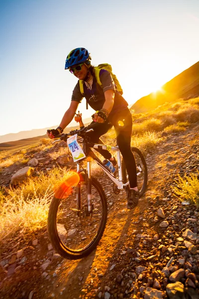 Girl on a bicycle in the rays of the rising sun — Stock Photo, Image