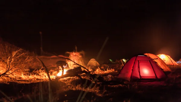 Övernattning i tält nära en eld — Stockfoto