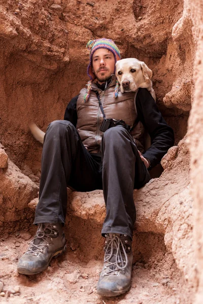 Un hombre camina en la montaña con perro labrador — Foto de Stock