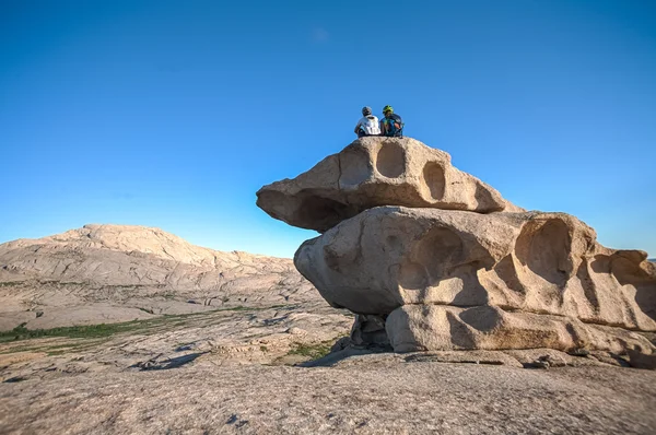 La gente en las montañas contempla el paisaje de piedra al atardecer —  Fotos de Stock