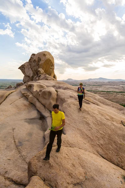 Insanlar dağlarda contemplates taş peyzaj gün batımında — Stok fotoğraf