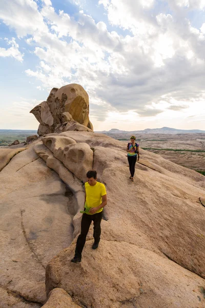 La gente en las montañas contempla el paisaje de piedra al atardecer —  Fotos de Stock