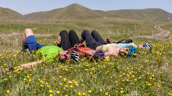 Personas acostadas en las flores silvestres de primavera — Foto de Stock