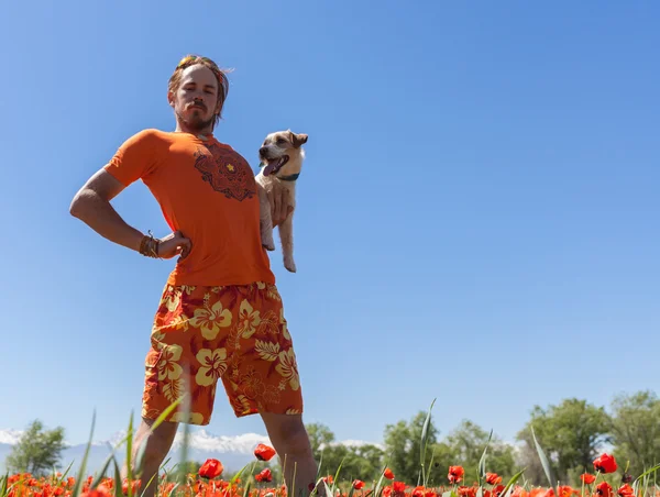 Homem correndo no campo de papoilas florescendo — Fotografia de Stock