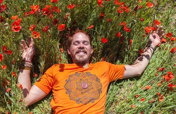 Um homem deitado na grama em flores — Fotografia de Stock