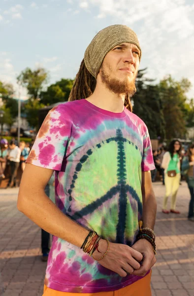 Människor i ljusa kläder med pacifistiska flagga — Stockfoto