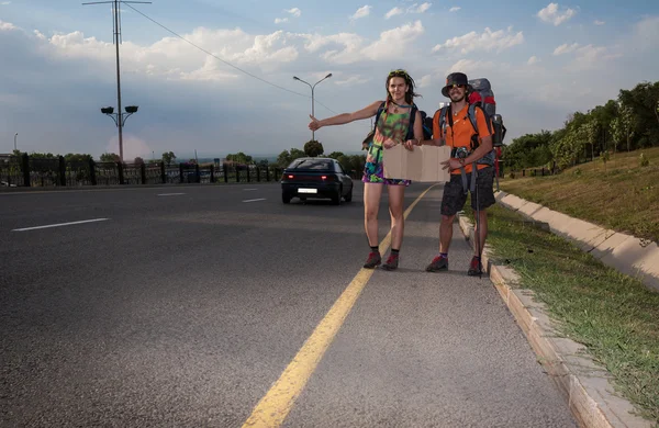 Due amanti Autostop, stand con un segno bianco — Foto Stock