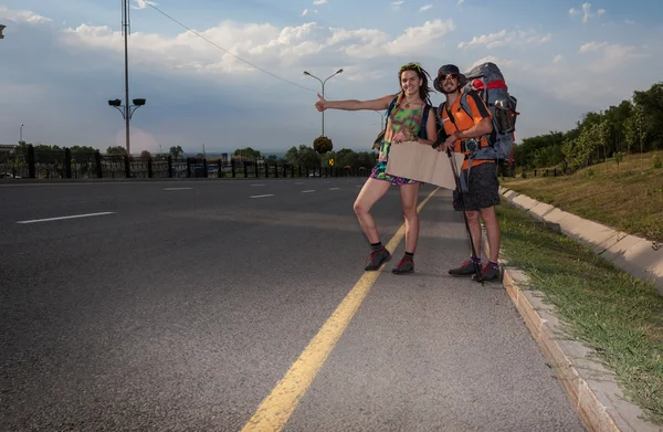 Due amanti Autostop, stand con un segno bianco — Foto Stock