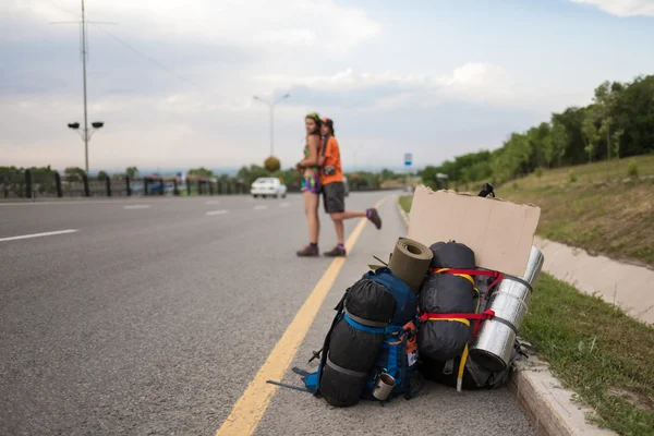 İki sevgili otostop, boş bir işareti ile stand — Stok fotoğraf