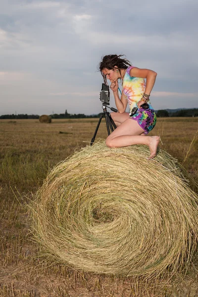 Vrouw fotograaf in veld in de kribbe — Stockfoto