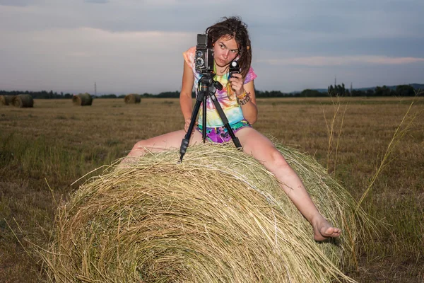 Woman photographer in field in the manger — Stock Photo, Image